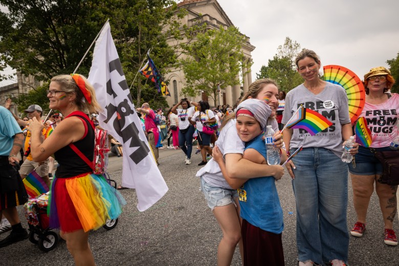 Mothers and siblings from the organization “Free Mom Hugs” give out hugs to audience members and parade volunteers.