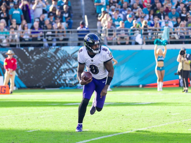 Ravens player Lamar Jackson runs on a football field.
