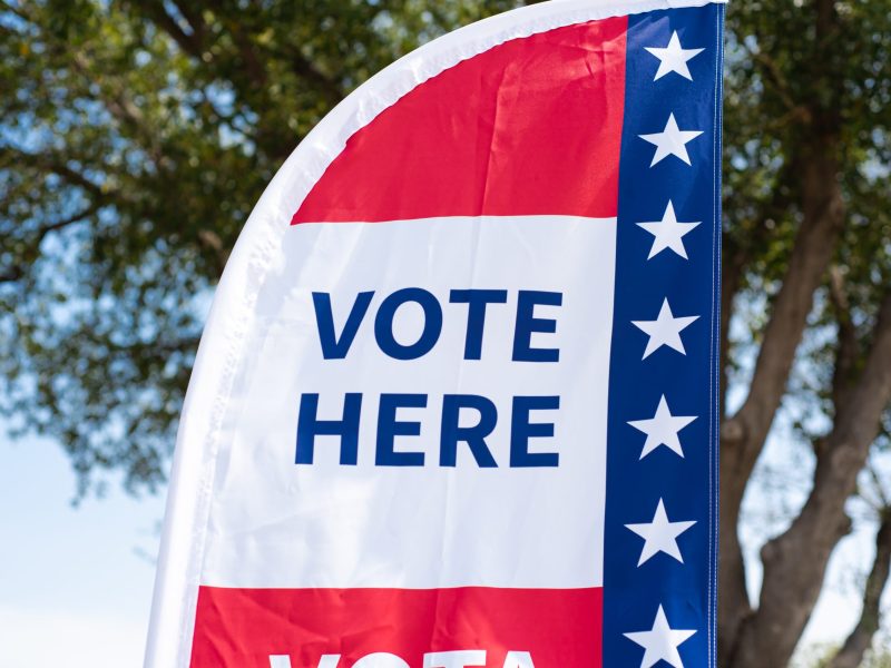 Vote Here high resolution text on political vote flag banner with fiberglass poles.