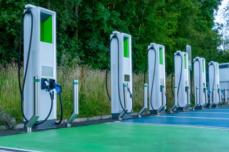 Electric Vehicle Charging Stations Arranged Neatly in Green Surroundings During Daylight Hours