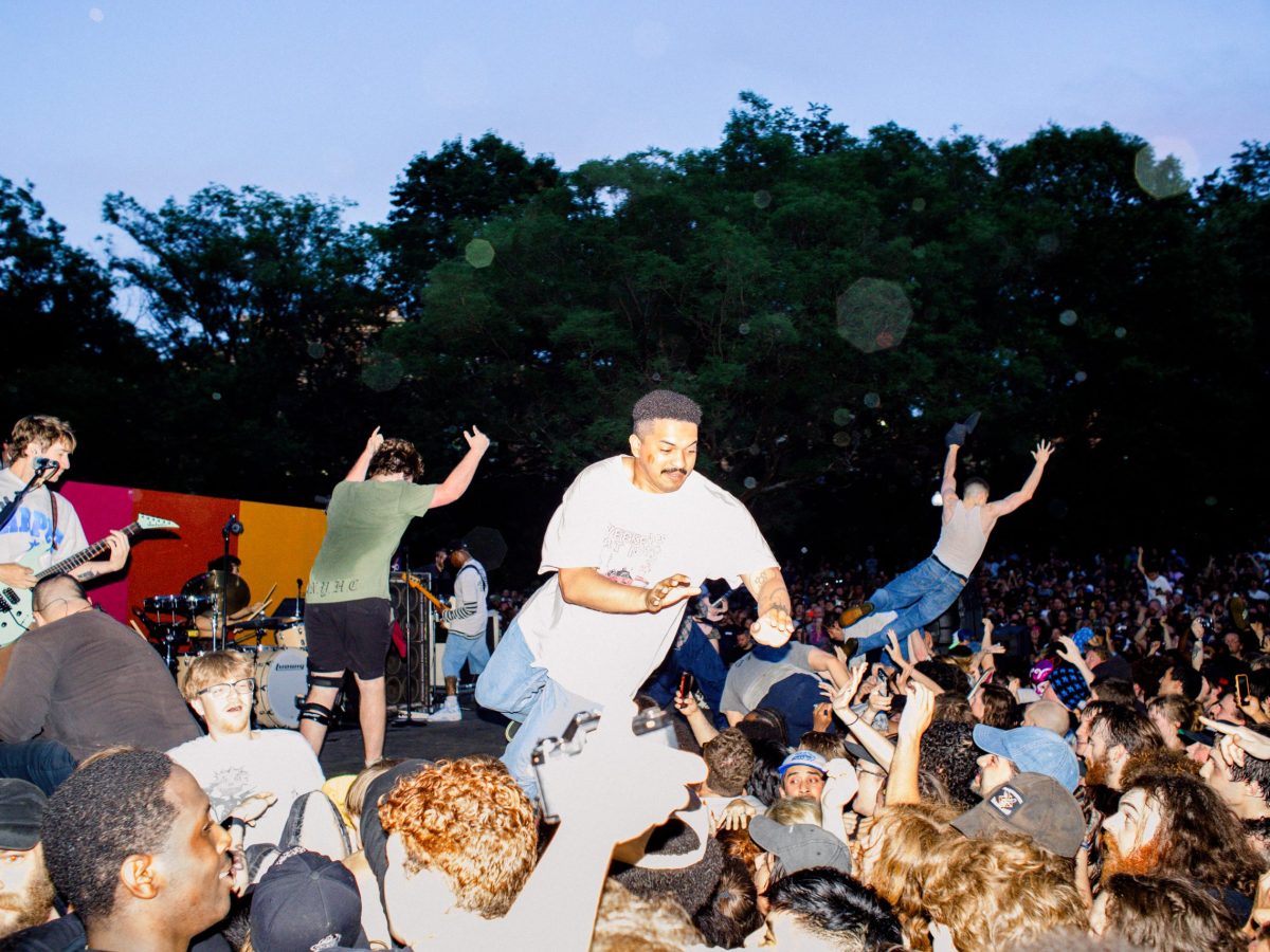 A group of people jump into a crowd at a hardcore rock concert