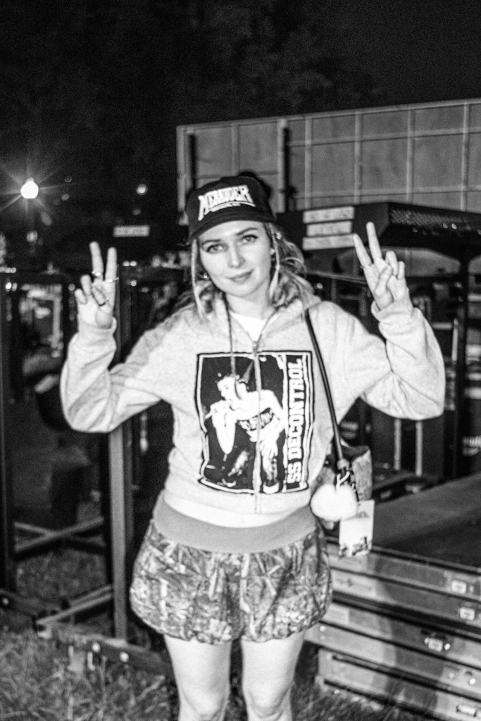 New guitarist, Meg Mills gives the camera two peace signs.