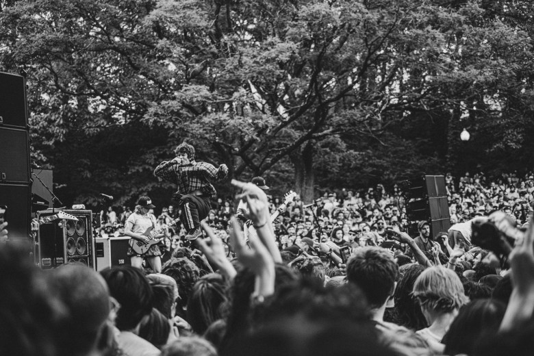 The band surrounded by a huge crowd of people.