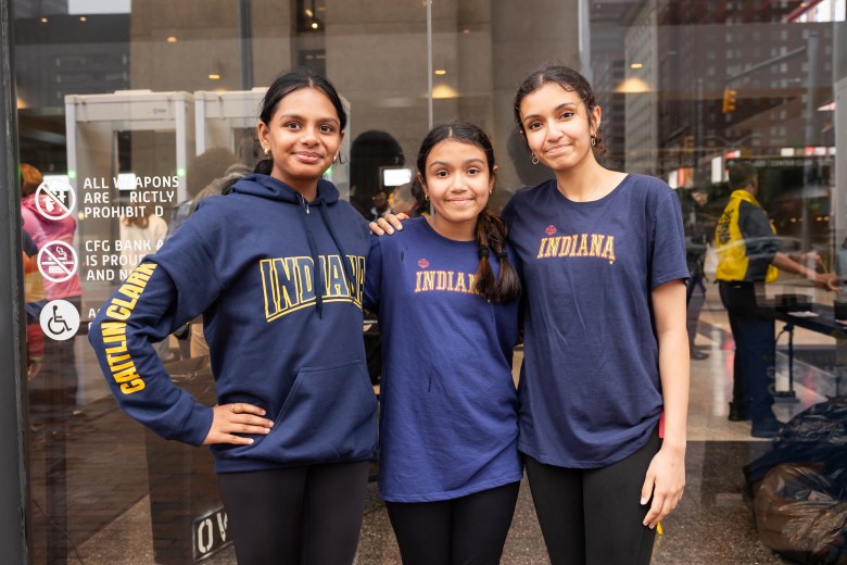 Three young people pose wearing blue Indiana Fever t-shirts and hoodies. 