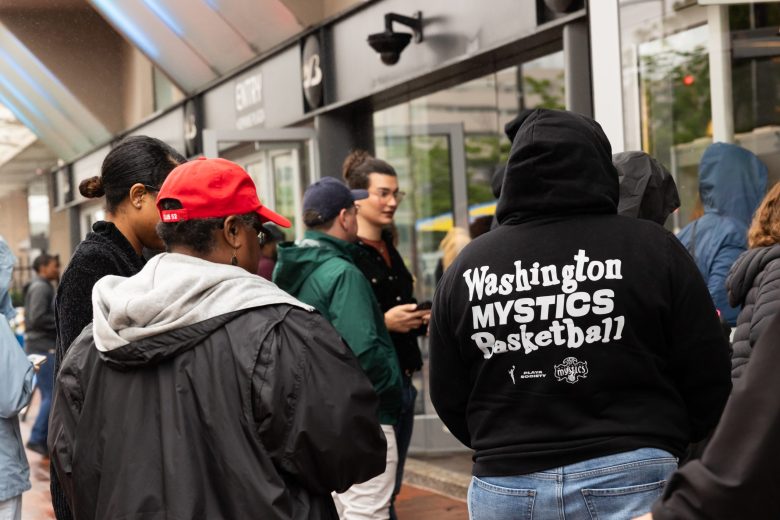 A picture of a crowd of people. One person is wearing a Washington Mystics hoodie.