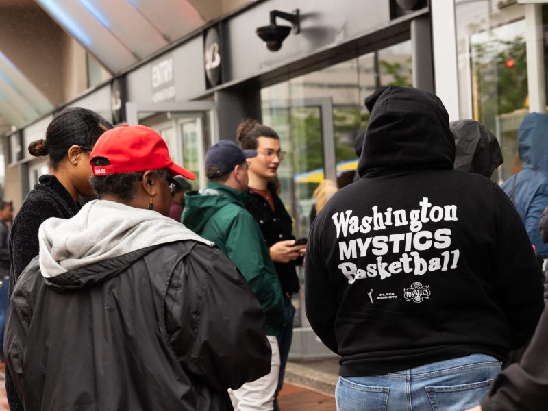 A picture of a crowd of people. One person is wearing a Washington Mystics hoodie.