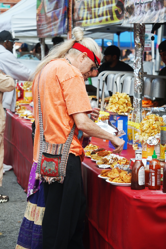 A person wearing an orange t-shirt and red headband prepares to eat.